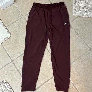 Maroon Nike dry fit, drawstring elastic waist. Working pocket zippers